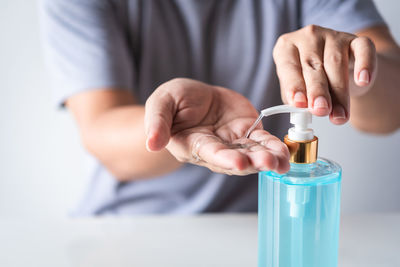 Midsection of person holding bottle