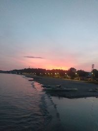 Scenic view of river against sky at sunset