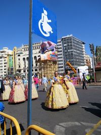 People on street against blue sky