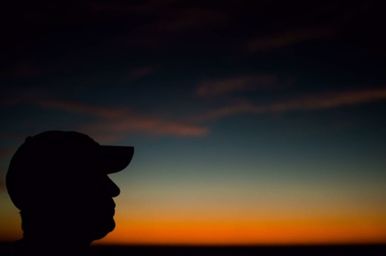 Silhouette of person holding orange