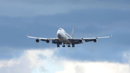 Low angle view of airplane flying against sky