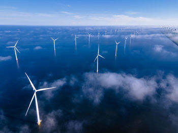 Wind turbines on landscape against sky