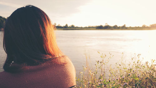 Rear view of woman looking at sea against sky