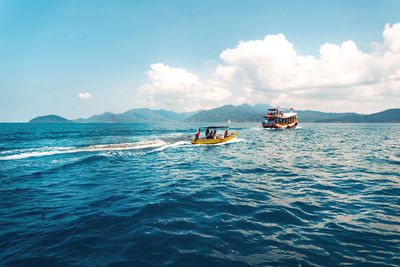 Boats sailing in sea against sky