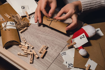 Cropped hands of woman playing with christmas decorations on table