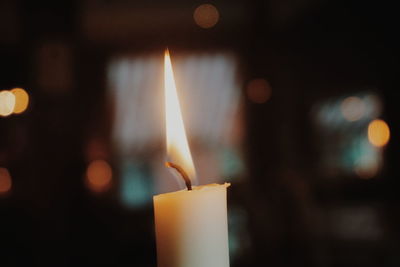 Close-up of lit candle in temple