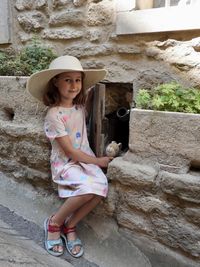 Portrait of young woman standing on steps