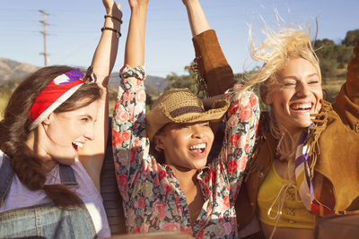 Cheerful friends looking away while sitting in convertible car