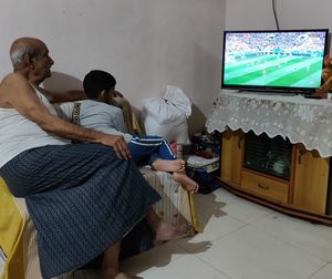 Grandfather and grandson watching tv at home