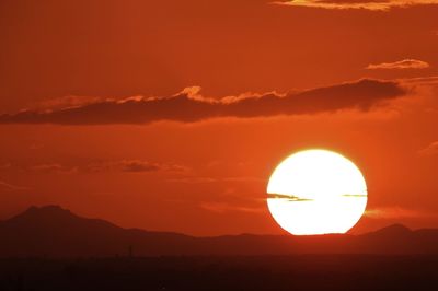 Scenic view of silhouette mountains against orange sky