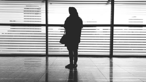 Rear view of silhouette woman walking on floor