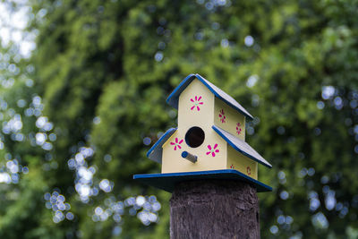 Low angle view of birdhouse on wooden post