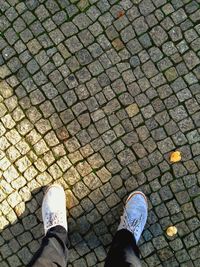 Low section of man standing on cobblestone street