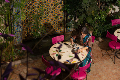 High angle view of girl sitting on chair at home