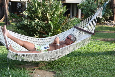Man sleeping on hammock in yard