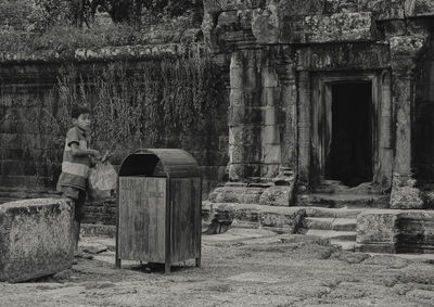 Rear view of man standing against old building