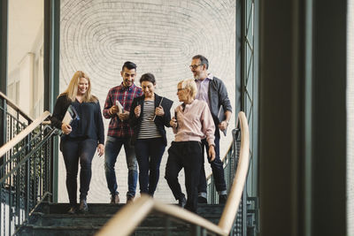 Team of creative business people moving downstairs at office