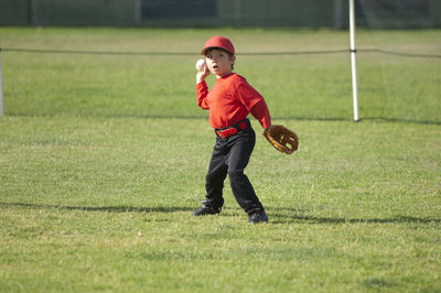 Young boy throwing a baseball on the tball field