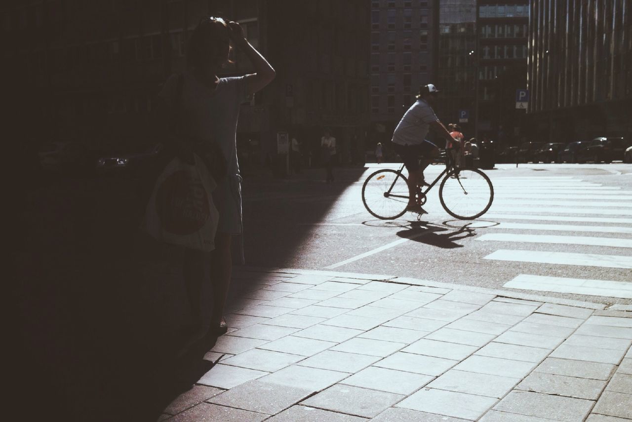 bicycle, transportation, land vehicle, street, mode of transport, building exterior, full length, architecture, built structure, city, riding, night, men, city life, lifestyles, shadow, parking, sidewalk