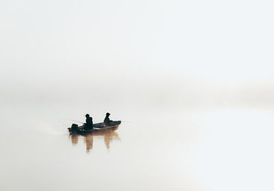 People in boat on sea against sky