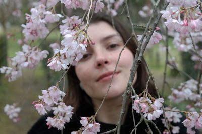 Portrait of beautiful woman against white flowering plants