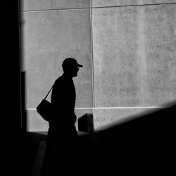 Silhouette man standing against wall