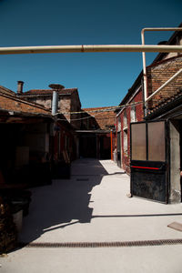 Street amidst buildings against sky during sunny day