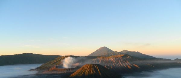 Scenic view of volcanic mountain against sky during sunset