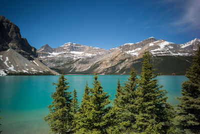 Scenic view of lake and mountains against blue sky