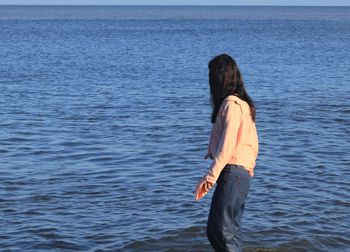 Rear view of woman standing in sea