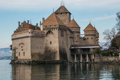 Building by river against sky