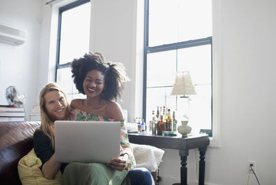 Woman sitting on mobile phone at home