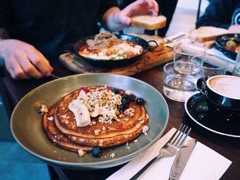 Midsection of person having food at table