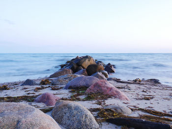 Rocks on beach against clear sky