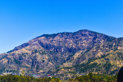 Scenic view of mountains against clear blue sky