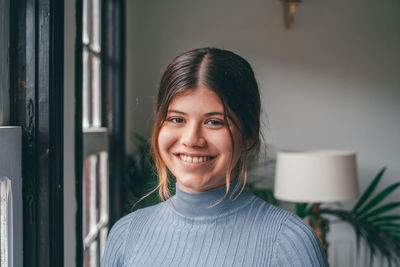 Portrait of young woman against wall