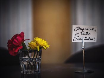 Flowers in glass by text on table