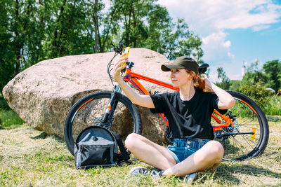 Side view of woman sitting on rock