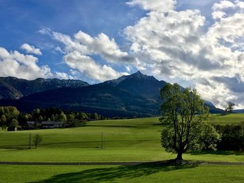 Scenic view of golf course and mountains against sky