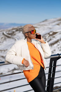 A young african american woman wearing sunglasses having fun in the snow on a winter day