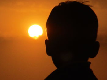 Silhouette of boy against sky during sunset