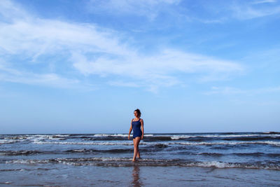 Full length of man standing on beach against sky