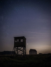 Tower on field against sky at night