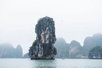 Rock formations in sea against clear sky