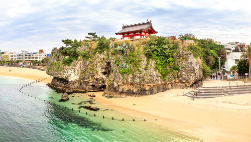 Panoramic view of japanese shinto shrine and beach against summer sky