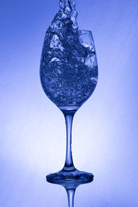 Close-up of glass of water against blue background
