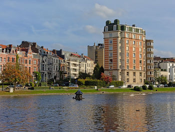 Buildings by canal against sky in city