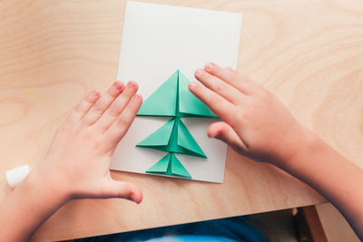 Step 5 of making christmas card. glue the prepared parts of the christmas tree on the card sheet