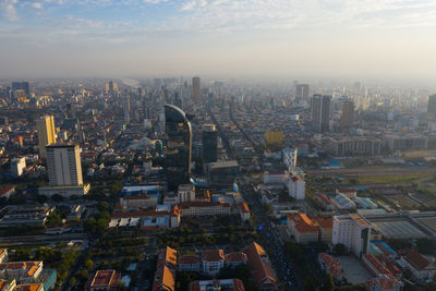 Aerial view of buildings in city against sky