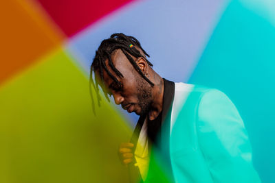 Man looking at multi colored umbrella